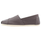 The TOMS Alpargata ESP - Women in grey is a low-profile slip-on canvas shoe with a rubber sole and simple stitching, shown side view on a white background. Classic style with TOMS signature buy one give one promise.
