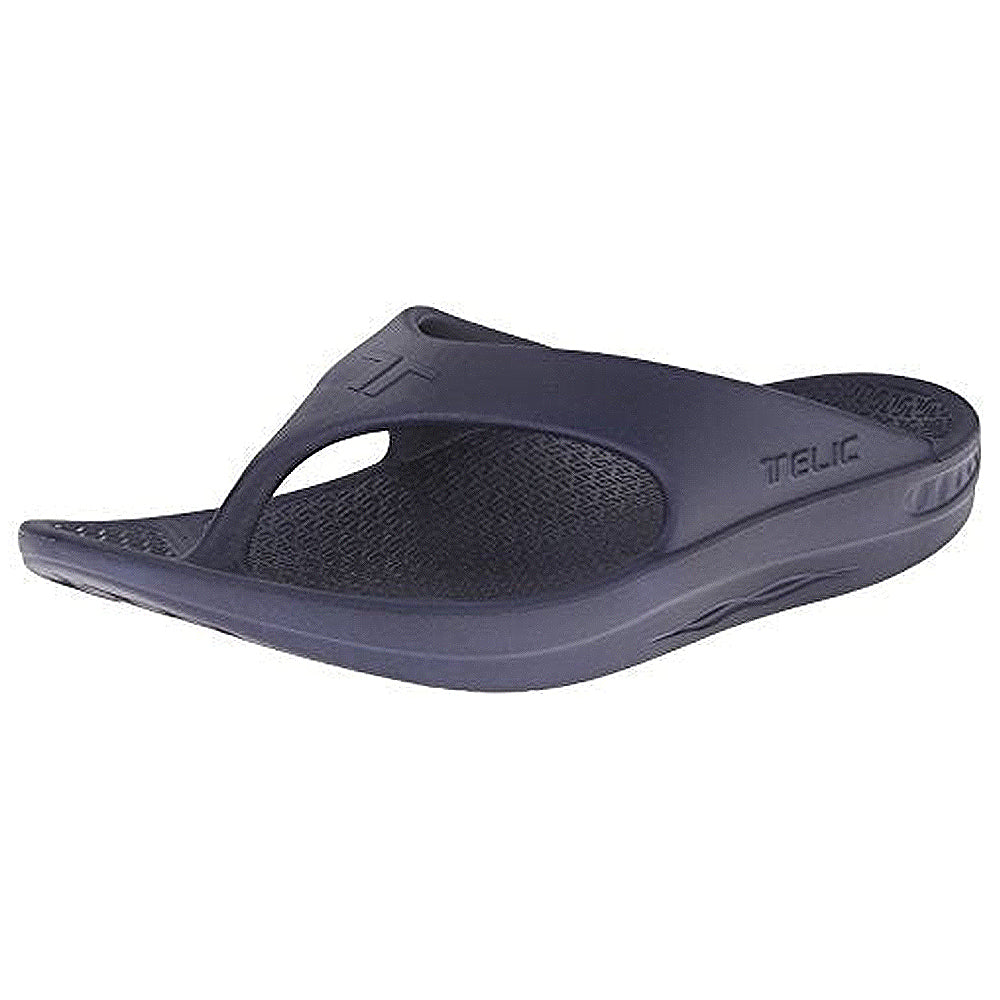 A single deep ocean Telic Footwear Energy Flip Flop - Unisex sandal features pillow-soft cushioning, a contoured footbed for arch support, textured sole, and TELIC branding embossed on the side.