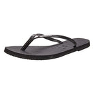 The Havaianas Slim Metalic - Womens flip flop in black features thin, glossy straps and a textured sole, displayed at an angle on a plain white background.