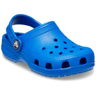 The Crocs Classic Clog - Kids in Blue Bolt features a textured sole, ventilation holes, and a pivoting heel strap—ideal for comfort and play.