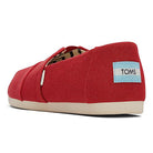 The TOMS Alpargata ESP - Women, in red recycled cotton canvas, features a beige rubber sole and displays the blue and white TOMS label on the heel, reflecting their buy one give one spirit. Viewed from the back left.
