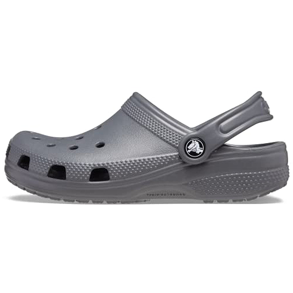 The Crocs Classic Clog - Kids in Slate Grey features ventilation holes, a textured footbed, and an adjustable heel strap, shown from the side on a white background.