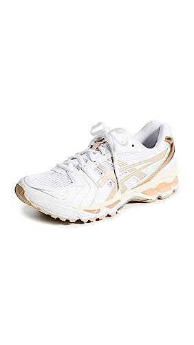 The ASICS Gel-Kayano 14 - Womenss sneaker showcases light beige and gold details, mesh panels, GEL Technology, and a chunky sole. Displayed angled with one untied lace for a sporty touch.
