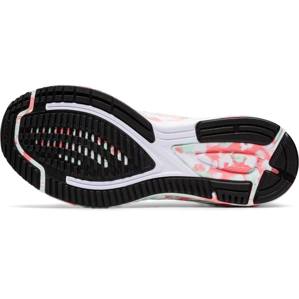 The image displays the sole of the ASICS GEL-NOOSA TRI 12 - Womens, with a black rubber tread, white and light pink accents, floral pink-and-green side print, and visible FLYTEFOAM midsole details.