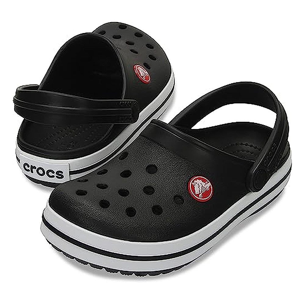The Crocs CrocBand Clog - Unisex features a black design with white soles, ventilation holes, red circular logos, and an adjustable heel strap, all in a water-friendly, lightweight build. One clog stands upright while the other is tilted.