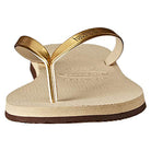 A close-up front view of the Havaianas Slim Metalic - Womens sandal in beige, featuring metallic gold straps with the Havaianas logo embossed, a textured footbed, and a slightly raised sole.