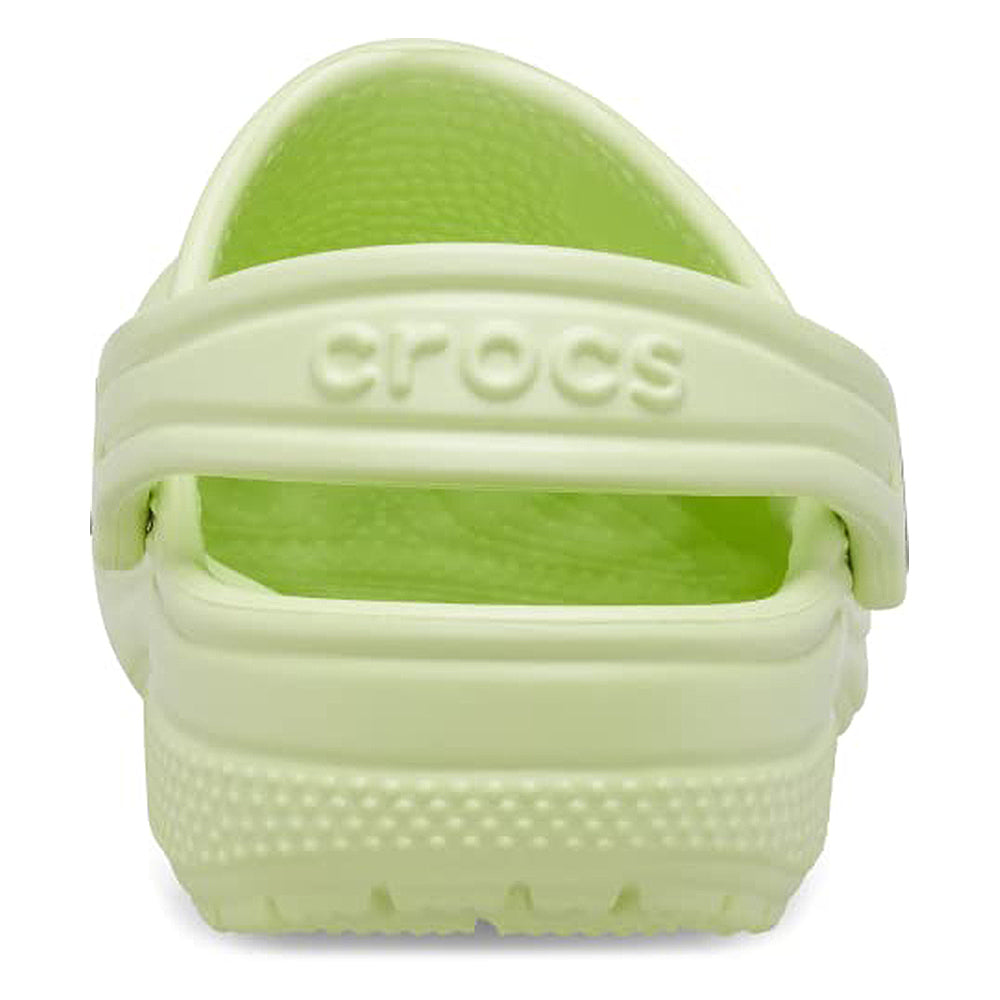 A close-up rear view of a light green Crocs Classic Clog - Kids shows the embossed heel strap and textured sole.