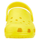 The Crocs Classic Clog - Kids is a bright yellow shoe with a back strap, shown from the front with ventilation holes on the top and sides.