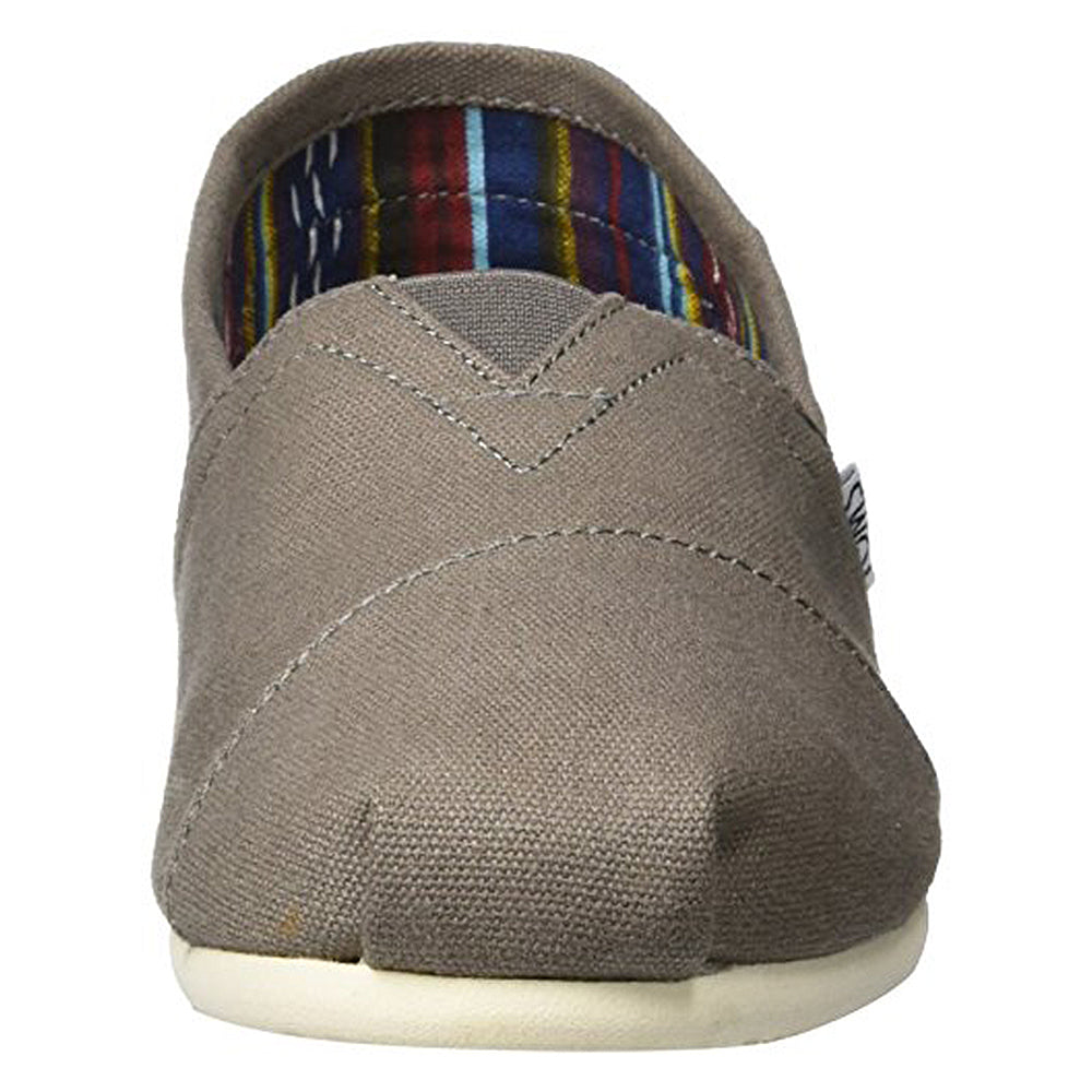 A front view of the TOMS Classic Canvas - Men slip-on shoe in gray, featuring visible stitching, a white sole, and a colorful striped inner lining.