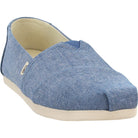A single light blue TOMS Alpargata ESP slip-on shoe for women, featuring a textured fabric upper, white sole, side logo tag, and embodying the brands classic design and One for One giving commitment.