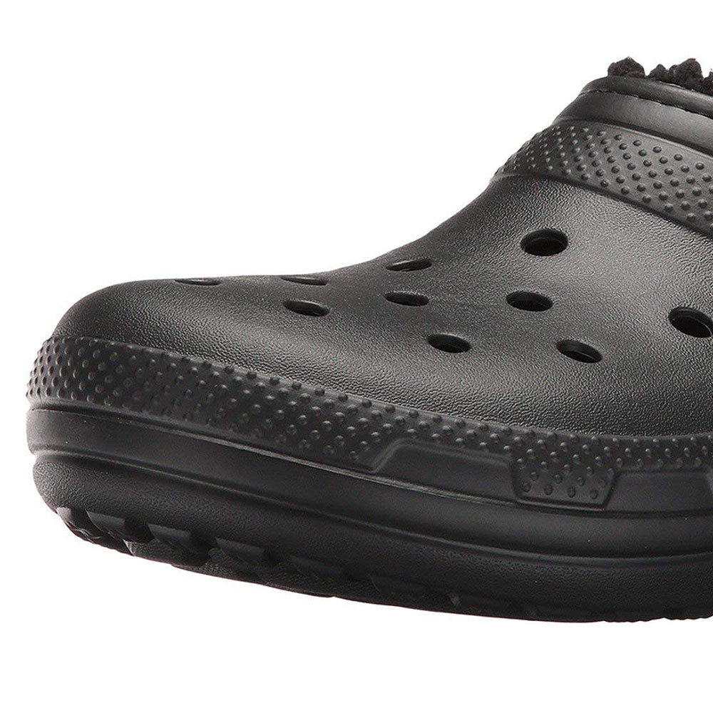 A close-up of the Crocs Classic Lined Clog - Unisex in black, featuring ventilation holes and a textured sole, photographed against a white background.