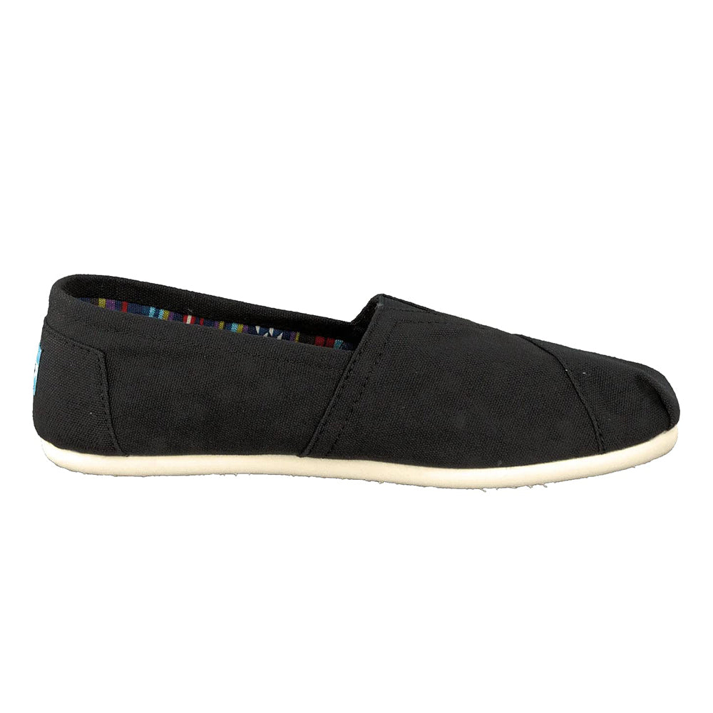 The TOMS Classic Canvas - Men is a black, low-profile slip-on with a white rubber sole and multicolored striped lining, featuring the iconic TOMS alpargata style and easy on-and-off design.