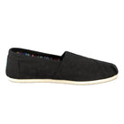 The TOMS Classic Canvas - Men is a black, low-profile slip-on with a white rubber sole and multicolored striped lining, featuring the iconic TOMS alpargata style and easy on-and-off design.