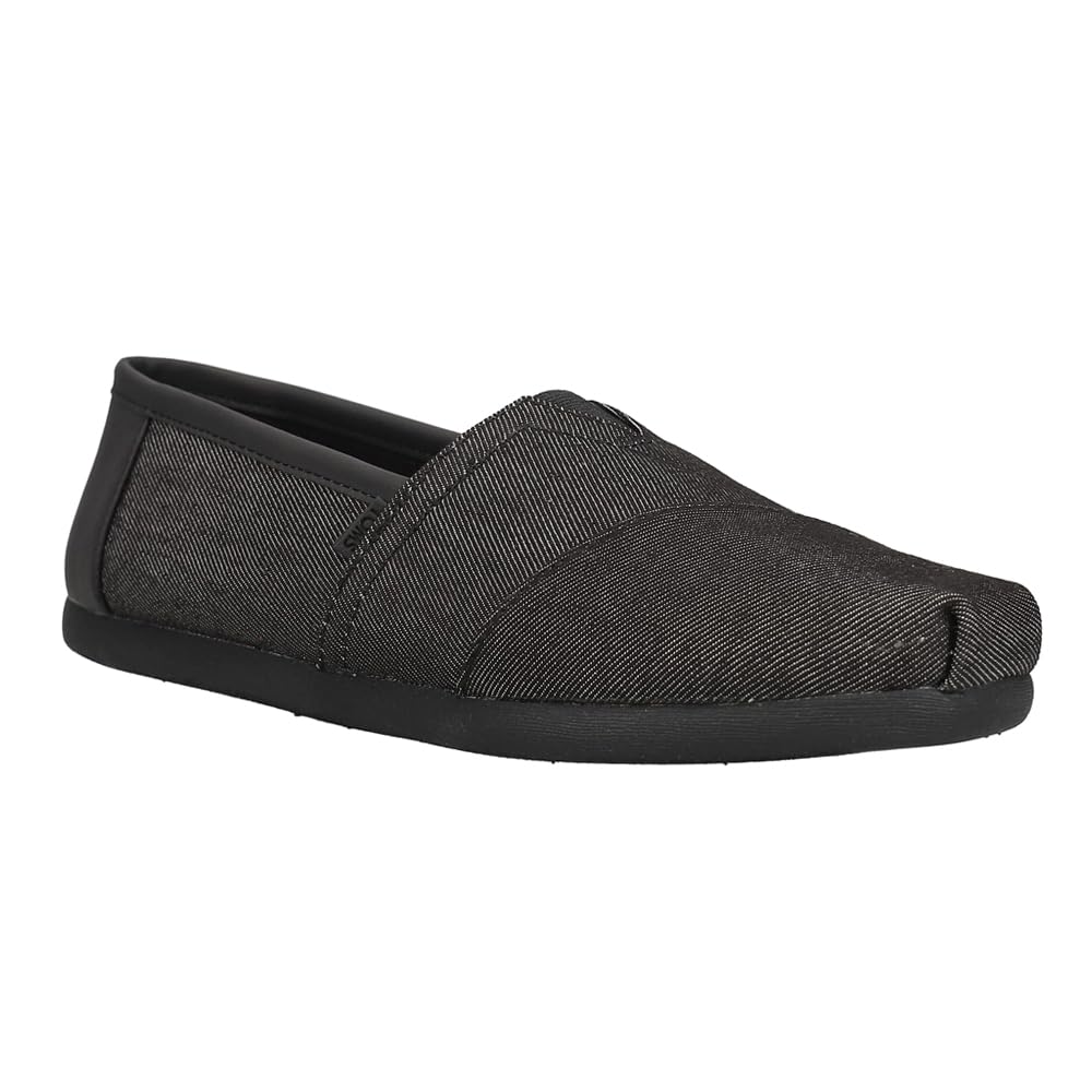 The TOMS Classic Canvas - Men is a black slip-on shoe with a classic alpargata design, minimal stitching, no visible laces, textured fabric, flat rubber sole, and a slightly pointed toe for casual comfort.