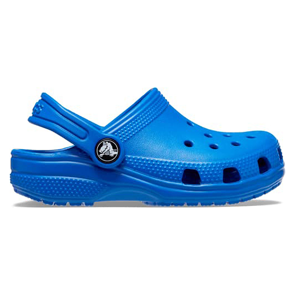 The Crocs Classic Clog - Kids is a bright blue shoe featuring ventilation holes and a pivoting heel strap, shown in side profile on a white background.