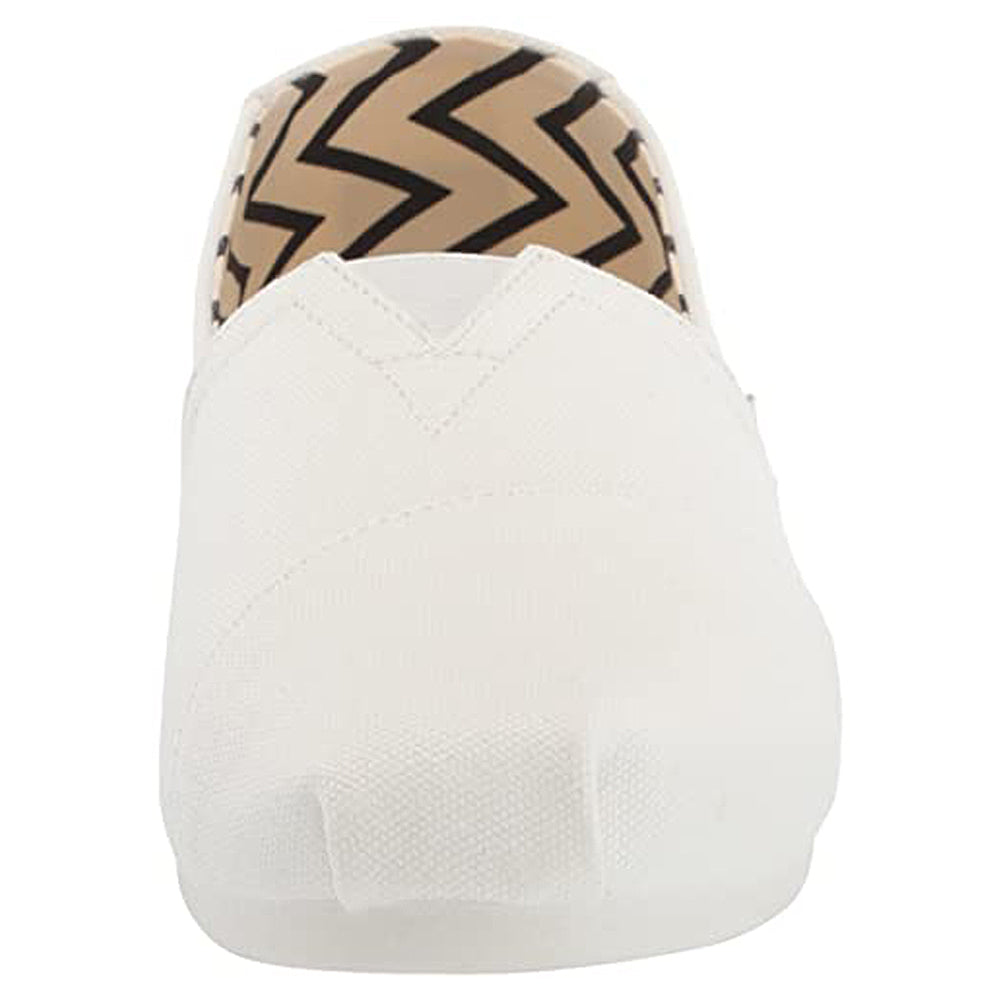 Front view of a white TOMS Alpargata - Womens slip-on, featuring a tan and black zigzag patterned inner lining from the earthwise collection.