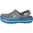 The Crocs Crocband Clog Seasonal Colors - Unisex, featuring ventilation holes, a blue and white striped sole, and an adjustable heel strap, is available in gray.