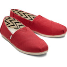 The TOMS Alpargata - Womens are red canvas slip-ons with beige soles and a black-and-white zigzag inner lining, made from recycled cotton in the earthwise collection.