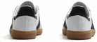 The adidas Samba Decon Shoes for men feature a leather upper in white with black accents and brown rubber soles, displayed from the back against a white background.
