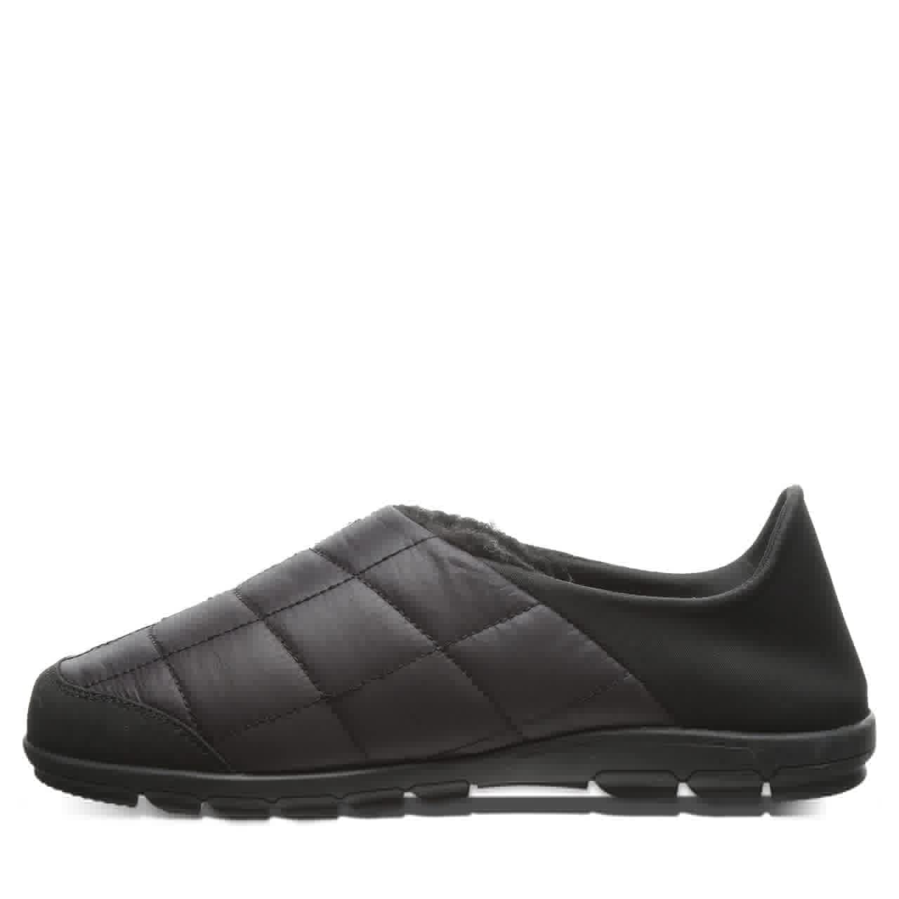 The BEARPAW Harry Slippers - Mens feature a black slip-on quilted mule design with a rubber sole, padded upper, and low back for cozy comfort, shown from the side on a white background.