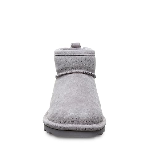Front view of a single BEARPAW Shorty Boots - Womens in light gray suede, featuring a rounded toe, flat rubber sole, and modern minimalist design.
