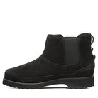 The BEARPAW Nick Boots - Mens, shown in left profile on a white background, feature black suede uppers, a low wedge heel, elastic side panel, back pull tab, and a textured rubber sole.