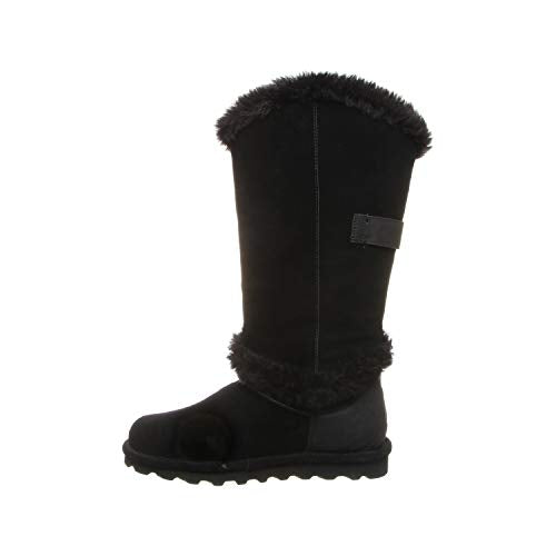 A single BEARPAW Sheilah Boot for women in black suede with faux fur trim at the top and ankle, a flat rubber sole, and a decorative side strap. The boot is shown in profile against a white background.