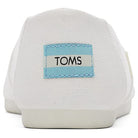 A close-up of the back of white TOMS Alpargata - Womens shoes shows a blue and white logo label on the heel, made from recycled cotton as part of the earthwise collection.