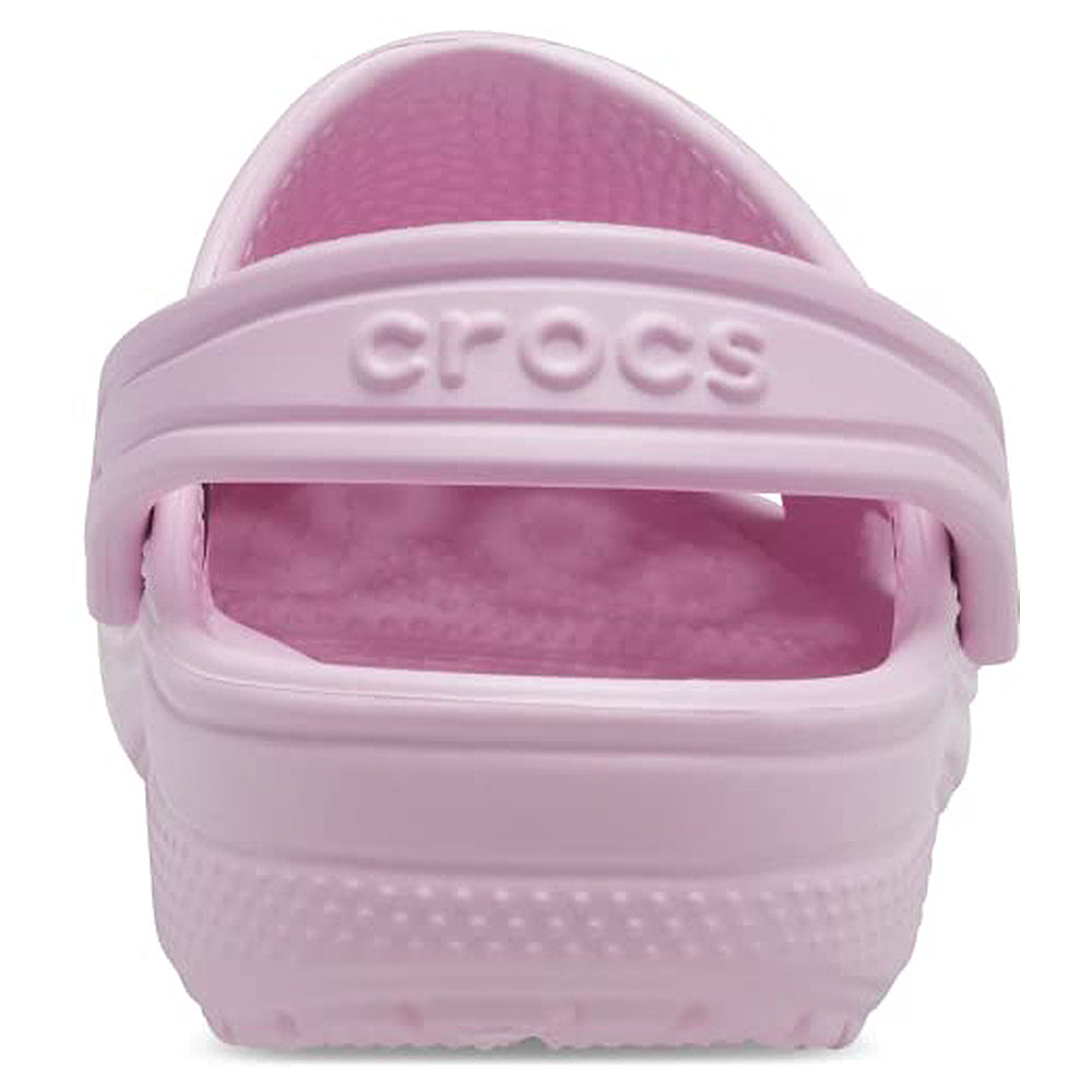 A close-up rear view of the light pink Crocs Classic Clog - Kids shows its textured sole, heel strap, and the word crocs embossed on the strap.