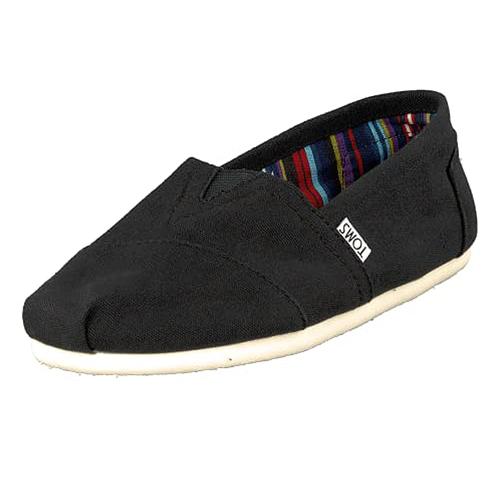 The TOMS Classic Canvas - Men is a black slip-on with a white sole, colorful striped inner lining, and a small TOMS tag on the side.