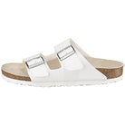 The Birkenstock Arizona - Womens sandal in white has double straps with metal buckles, a cork footbed, and a white sole for orthopedic comfort. Shown from the side.