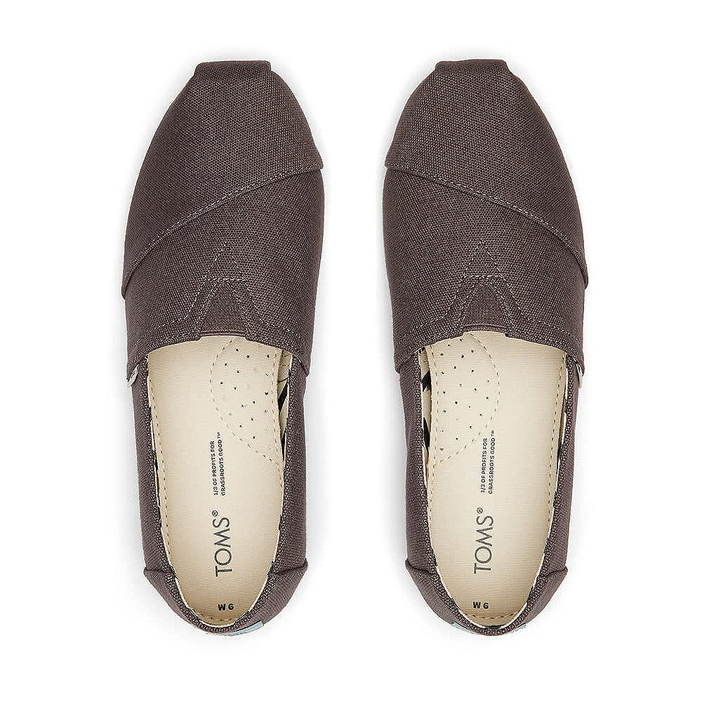 A pair of TOMS Alpargata - Womens slip-on shoes in brown, seen from above, showcasing insoles crafted with recycled cotton and the iconic stitched detailing, part of the earthwise collection.