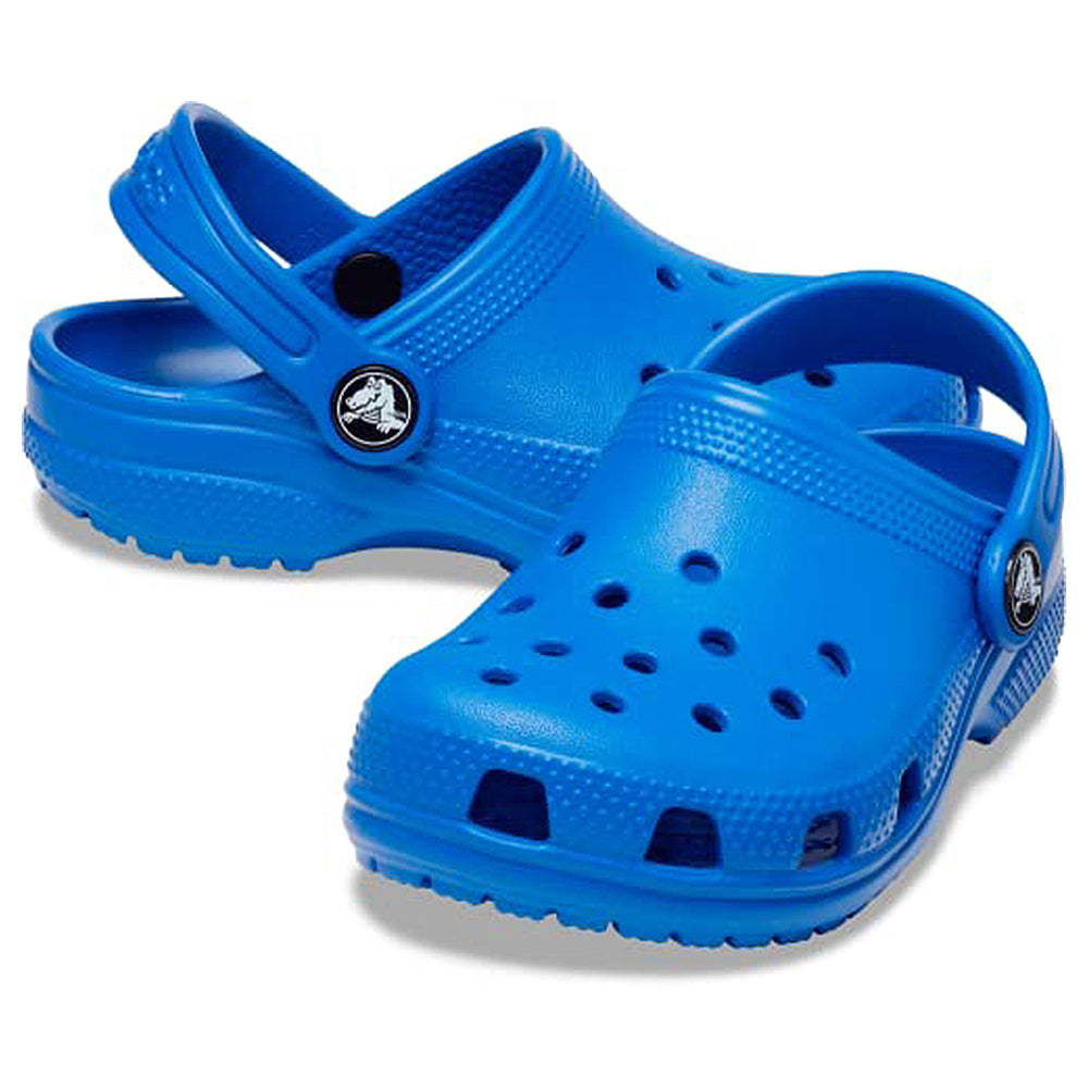The Crocs Classic Clog - Kids, shown in bright blue with ventilation holes and heel straps, is displayed against a white background.