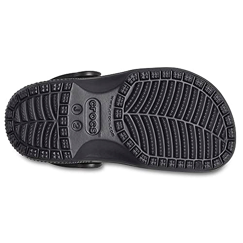 The image shows the bottom sole of a black Crocs Classic Clog - Kids shoe with a textured, non-slip pattern and the Crocs logo and website printed in the center.