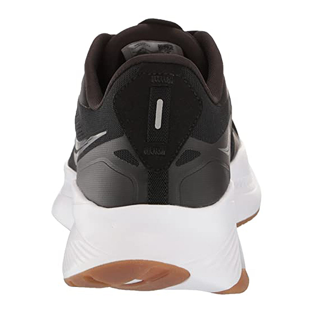 Rear view of the Saucony Guide 15 - Men: a black running shoe featuring a cushioned white midsole, durable brown rubber outsole, and a reflective vertical heel strip for lightweight support.