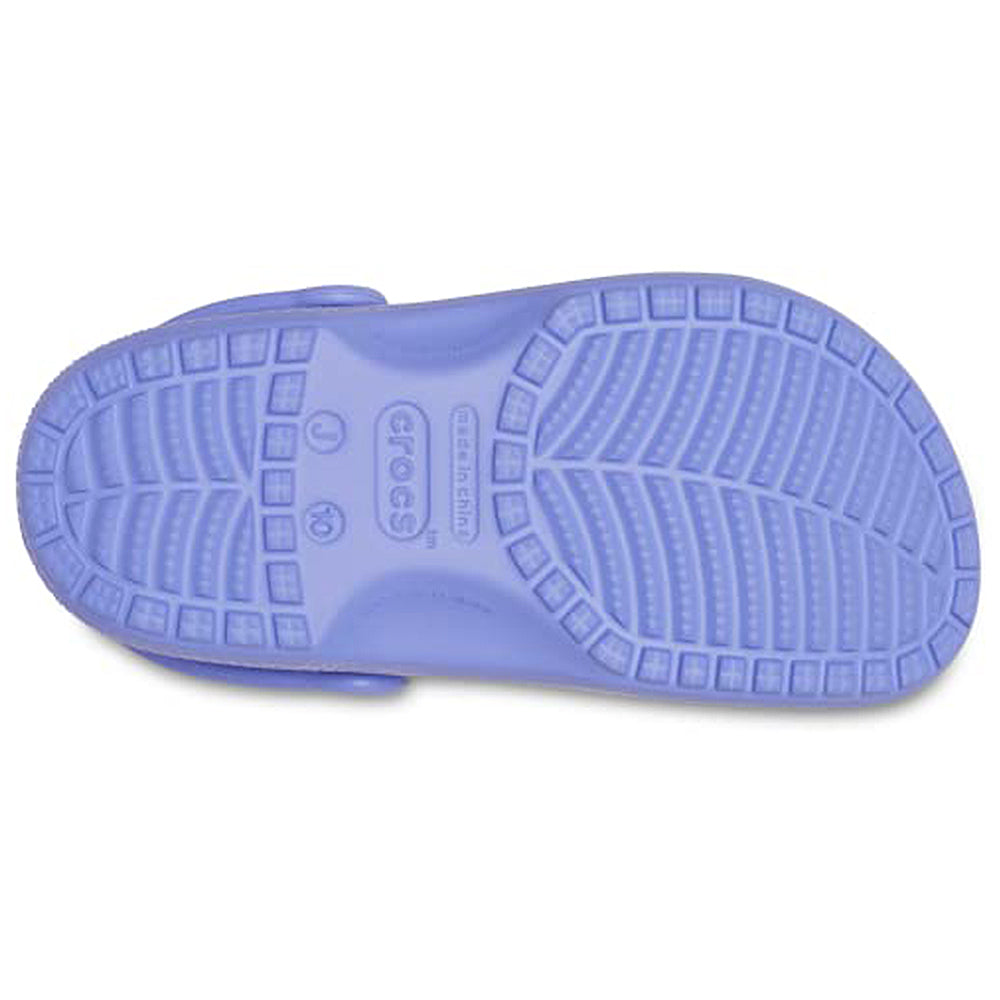 The image shows the sole of a Crocs Classic Clog - Kids in light purple, featuring a textured tread pattern and a Crocs brand marking near the heel.