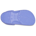 The image shows the sole of a Crocs Classic Clog - Kids in light purple, featuring a textured tread pattern and a Crocs brand marking near the heel.