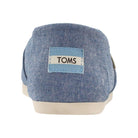 Back view of the TOMS Alpargata ESP - Women in light blue fabric, featuring a white sole, stitched TOMS heel label, classic slip-on design, and representing the brand’s buy one give one philosophy.