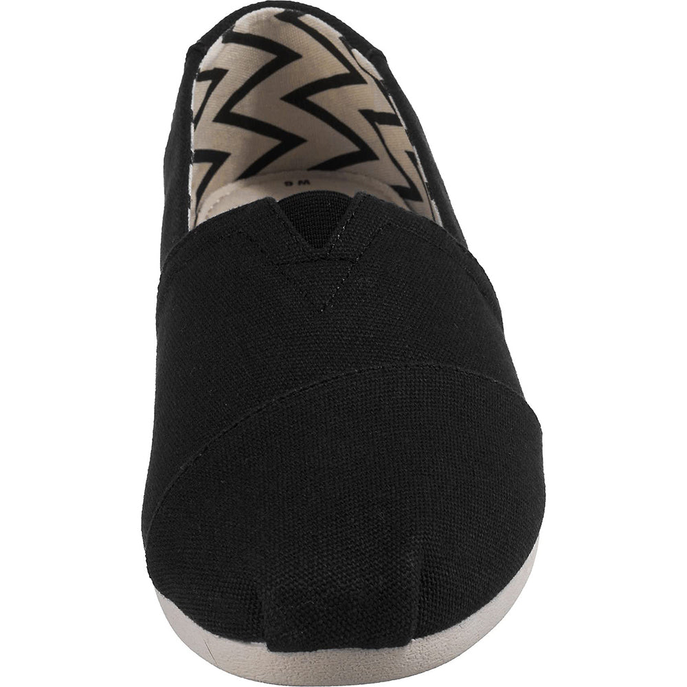 The TOMS Alpargata - Womens slip-on shows a black front view with a rounded toe and beige/black zigzag inner lining, crafted from recycled cotton as part of the earthwise collection.