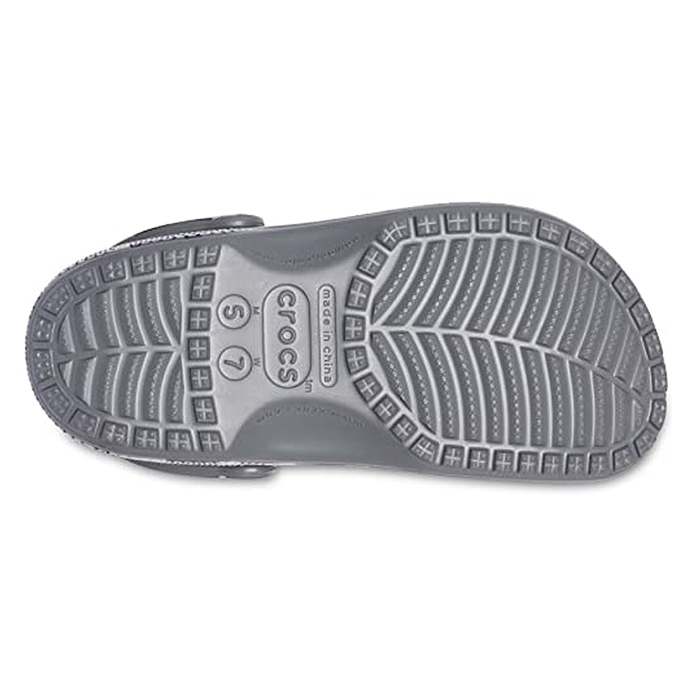 The image displays the sole of a Crocs Classic Camo Clog - Unisex, featuring a textured tread, Crocs branding, and size marks (S7, M5). These slip-on shoes are known for comfort and function as water shoes.