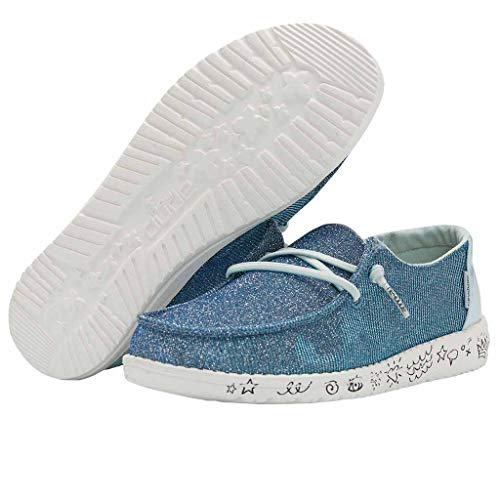 A pair of Hey Dude Wendy Youth - Girls shoes in light blue glitter with white, lightweight soles. One shoe stands upright, the other lies on its side, highlighting playful doodles and symbols on the sole.