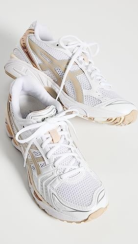 A pair of ASICS Gel-Kayano 14 - Womens sneakers in white with beige and tan accents, white laces, mesh panels, and GEL Technology cushioning, displayed on a white background.