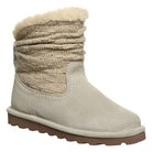 The BEARPAW Virginia Boots for women feature a light beige sheepskin design, wool knit shaft, faux fur lining, and a flat brown sole for warmth and comfort.