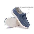 The Hey Dude Wendy Youth - Girls shoes feature a blue design with white soles. One lightweight shoe stands upright, highlighting elastic laces and the Easy-On system; the other reveals the patterned inner lining and textured sole.