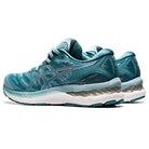 A pair of ASICS Gel Nimbus 23 - Womens running shoes in teal with silver accents, mesh uppers, white midsoles, and teal outsoles are shown side by side at a slight angle for superior shock absorption.