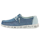 The Hey Dude Wendy Youth - Girls slip-on features blue fabric, white laces, a white sole with fun black doodles—stars, waves, hearts, clouds—and offers lightweight comfort and playful style for girls.