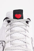 Close-up of the Saucony Endorphin Speed 3 Running Shoe - Womens, featuring white and gray laces with a small red heart on a black tongue tag—ideal for daily training.