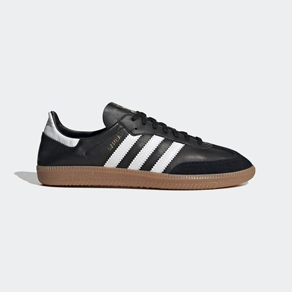 The adidas Samba Decon Shoes - Men are shown in side profile with a black leather upper, white stripes, gum rubber sole, and gold Samba text, highlighting their timeless design against a plain gray background.