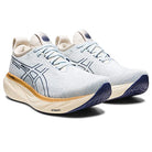 A pair of ASICS Gel Nimbus 25 - Womens shoes in light blue with dark blue accents, white laces, and beige soles. These running shoes feature a cushioned, textured sole for support and display the ASICS logo.