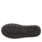The image shows the black rubber sole of a shoe with a rugged, wavy tread for traction. The center features branding, similar to the BEARPAW Elle Short Vegan Boots - Womens sole with NeverWet technology.
